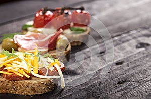 Set of different bruschettas on dark wooden table. Front view and copy space.