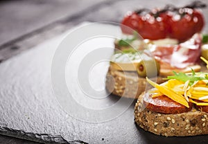 Set of different bruschettas on dark wooden table. Front view and copy space.