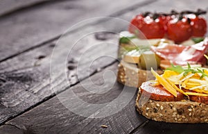 Set of different bruschettas on dark wooden table. Front view and copy space.