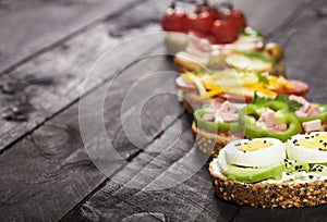 Set of different bruschettas on dark wooden table. Front view and copy space.