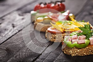 Set of different bruschettas on dark wooden table. Front view and copy space.