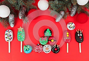 Set of different Christmas cookies donats and cakesicles on red background. Christmas decorations. photo