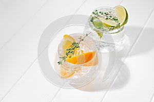 Set of different citrus lemonades with orange and lime on a light background. Tough sunshine. Flashy food