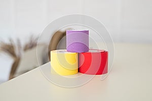 Set with different color kinesio tapes on pastel background. Kinesiology, physical therapy, rehabilitation concept