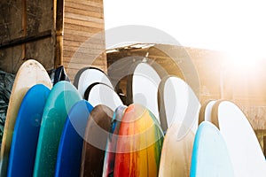 Set of different color surf boards in a stack by ocean.Bali.Indonesia. Surf boards on sandy beach for rent. Surf lessons