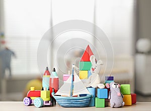 Set of different cute toys on wooden table in children`s room