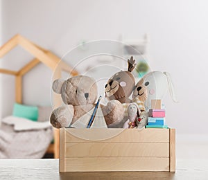 Set of different cute toys on wooden table in children`s room