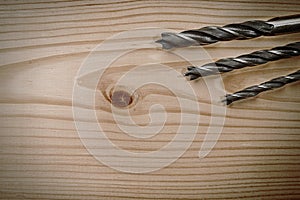 Set of different drill bits on wooden background