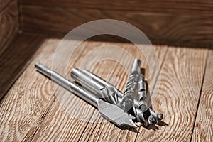 Set of different drill bits on wooden background