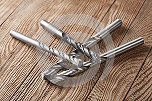 Set of different drill bits on wooden background