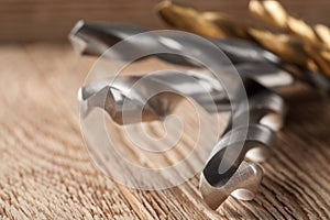 Set of different drill bits on wooden background