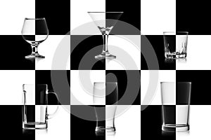 Set of different empty glasses for alcoholic drinks isolated on the chessboard. Glassware game concept for alcohol