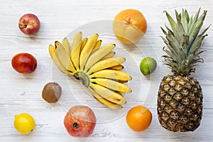 Set of different fresh tropical fruits over white wooden background