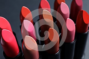 Set of different lipsticks on grey background, closeup.