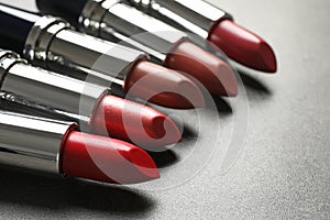 Set of different lipsticks on grey background