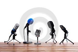 Set of different microphones on wooden table
