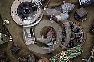 Set of different old car parts. On a dark tarpaulin.