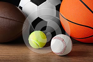 Set of different sport balls on wooden surface, closeup