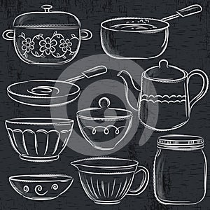 Set of different tableware on blackboard