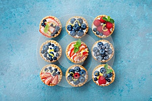 Set of different tartlets or cake with cream cheese and summer berry. Pastry dessert top view.