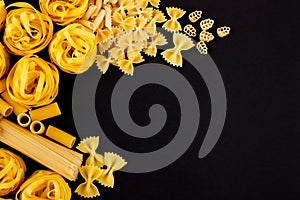 Set of different types of pasta on the black background