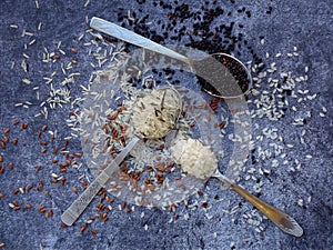 Set of different types rice on grey background: white glutinous, black, basmati, brown and mixed rice. Healthy concept. Top view.