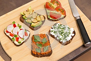 Set different vegan, vegetarian toasts. Homemade smorrebrod with vegetables, avocado, tomato, olive, hummus, cucumber