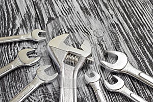 Set of different wrenches on a black wooden table.