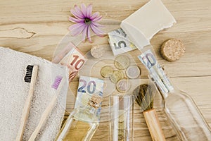 Set of different zero waste beauty products on wooden background with euro money bank notes.