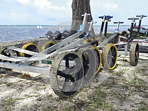 Set of dinghy sailing carts on the beach near the sea and unfocused background. Boat trailers. Beach carts background