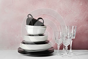 Set of dinnerware on table against color background.