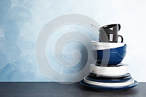 Set of dinnerware on table against color background with space for text. Interior element