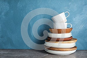 Set of dinnerware on table against color background with space for text.