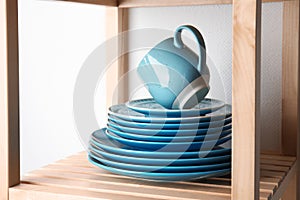 Set of dinnerware on wooden shelf