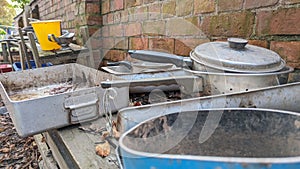 A set of dirty kitchen pots and pans in an outdoor mud kitchen