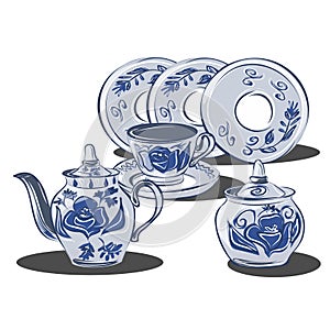 A set of dishes in the gzhel style with blue flowers. Porcelain and earthenware ceramic items for table setting. Teapot, sugar bow