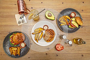 Set of dishes with hamburgers with brioche bread, ripe avocado, iced drinks,