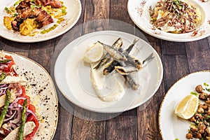 Set of dishes with Spanish tapas recipes with fried anchovies, grilled octopus, ventresca salad and criadillas photo