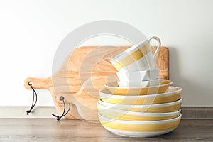 Set of dishware on table against light background.