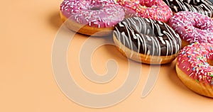 A set of donuts close-up on a beige color background with copy space