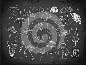 Set of doodle sketch umbrellas on blackboard background