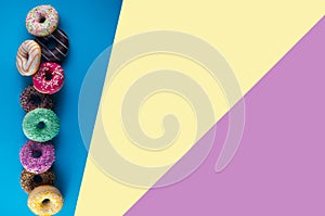 Set of doughnuts on blue, yellow and purple background.