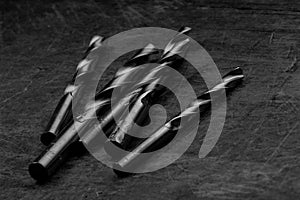 Set of drill bits on wooden background. Symbolic repair tool