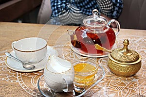 A set for drinking tea, a cup and thrush, covered with bronze lids, close-up view.