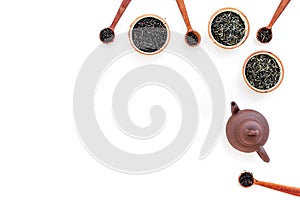 Set of dry tea leaves in bowls and spoons for tea ceremony on white background top view copy space