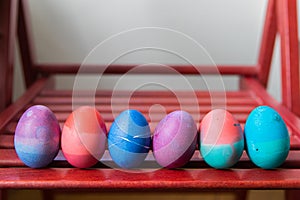 Set of easter eggs standing on red chair background