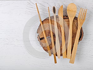 Set of Eco friendly bamboo cutlery on wooden backing. Sustainable lifestyle. Plastic free concept. Top view, flat lay, mockup