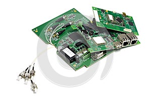 Set of electronic printed circuit boards with optic connectors attached and other components, angled view, isolated on white