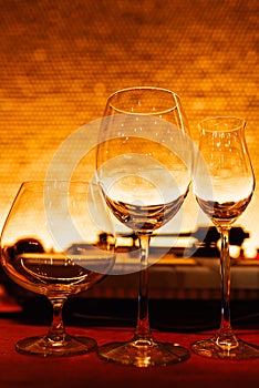 Set of empty glasses for different drinks, warm orange tinted. Empty wine glass, cognac glass and liquor glass/