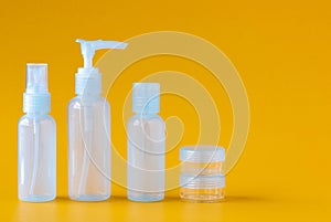 Set of empty mini blue bottles for cosmetics on a yellow background, side view, copy space.